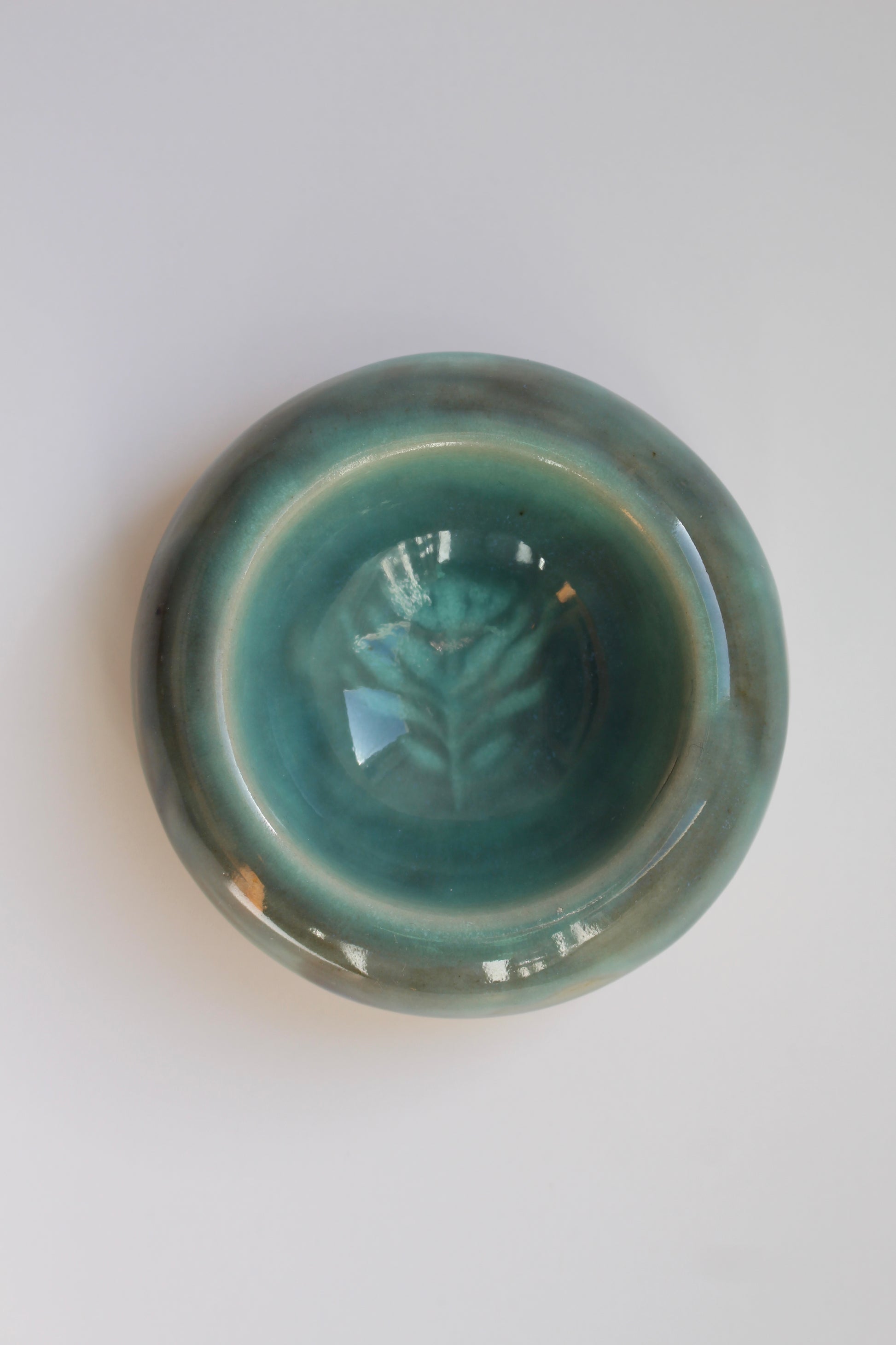 Green ceramic dish with leaf design on a white background